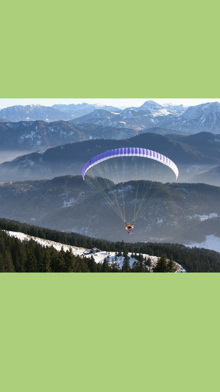 Ein Paraglider der über ein Gebirge fliegt, er lebt einen trendigen Lifestyle